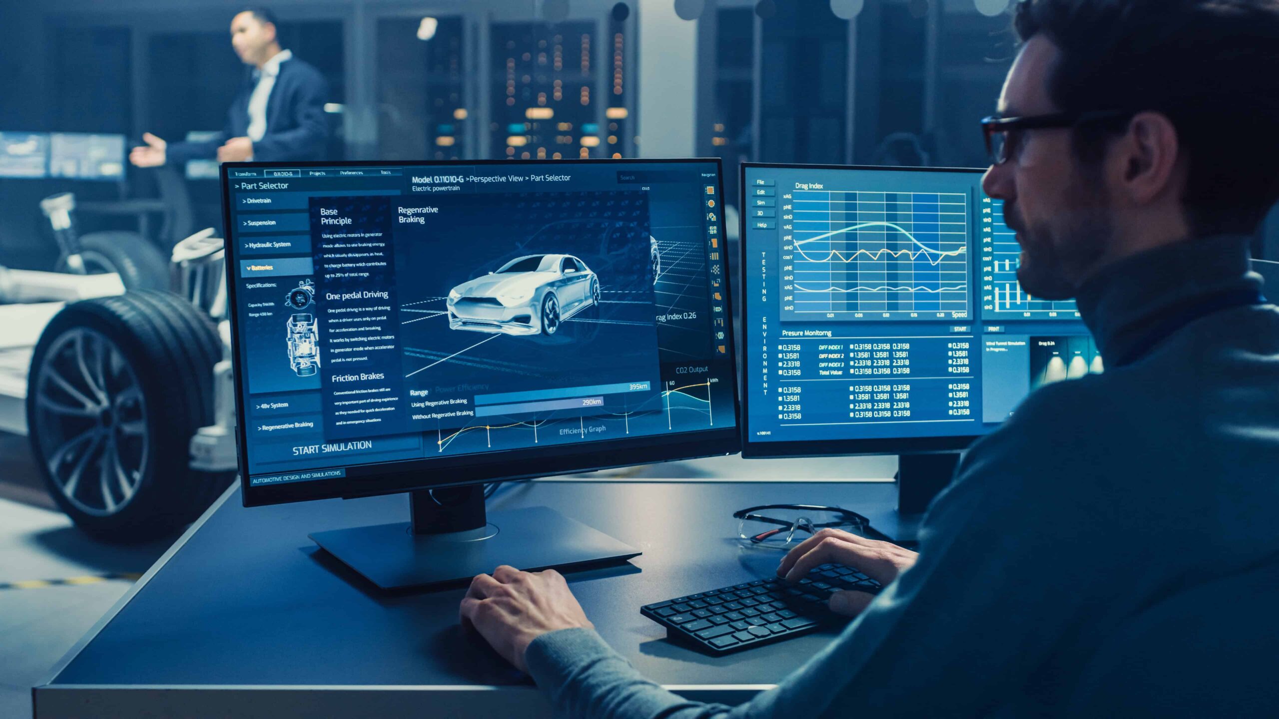 Automotive data analysis and simulation on dual monitors in a modern office.