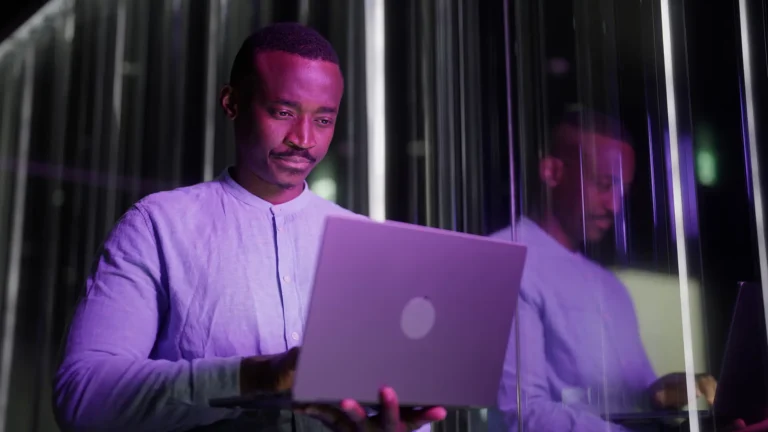 Black ethnic businessman using his laptop in modern office
