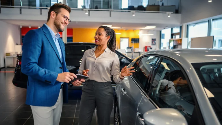 Salesman helping the male customer to choose a new car